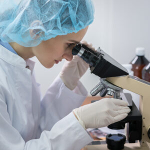 female doctor testing with microscope
